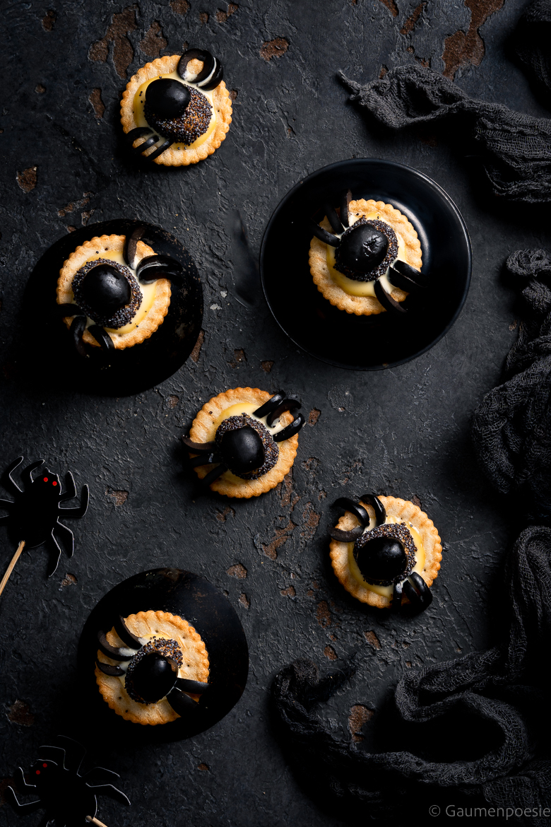 Hier sieht man Kekse mit aus Oliven geformten Spinnen 
